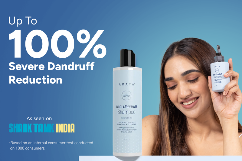 Woman holding a bottle of shampoo with text about dandruff reduction on a blue background