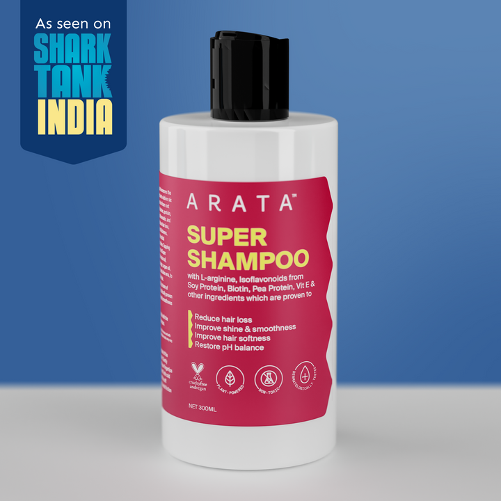 Arata Super Shampoo bottle with pink label on a blue background, featuring Shark Tank India logo.